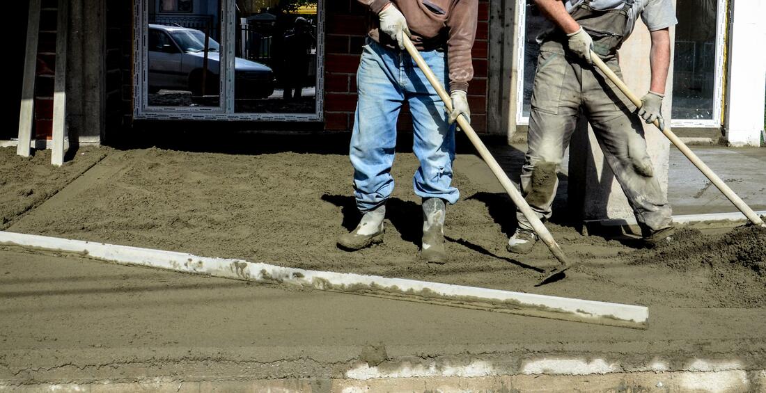 Men pouring a stamped concrete driveway